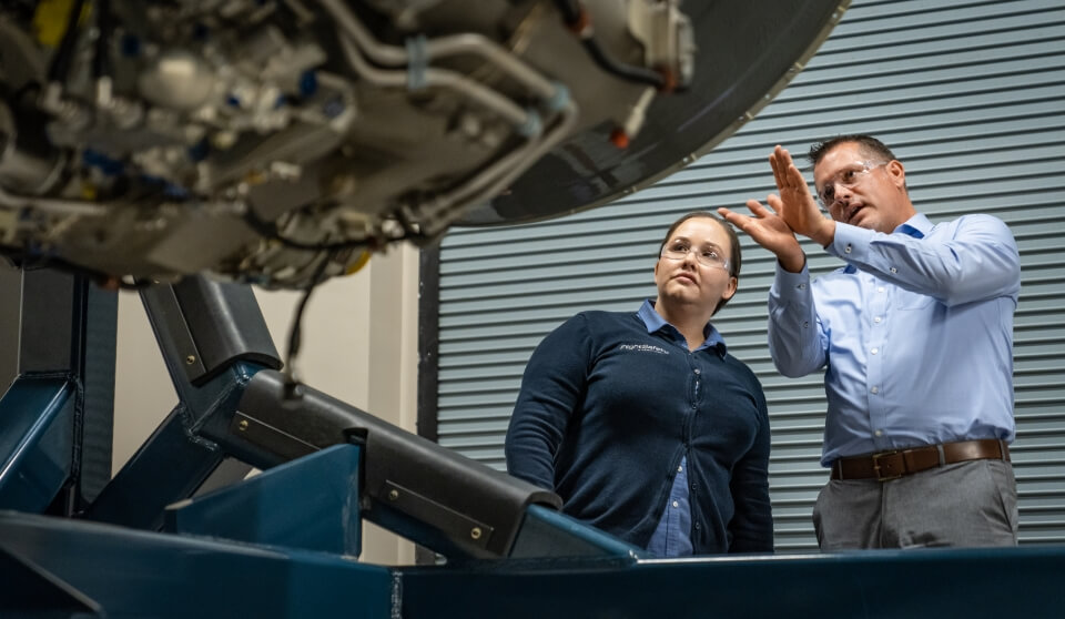 Two FSI employees discussing simulator equipment.