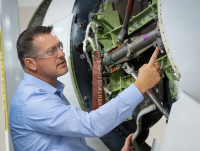An FSI employee pointing to aviation equipment.