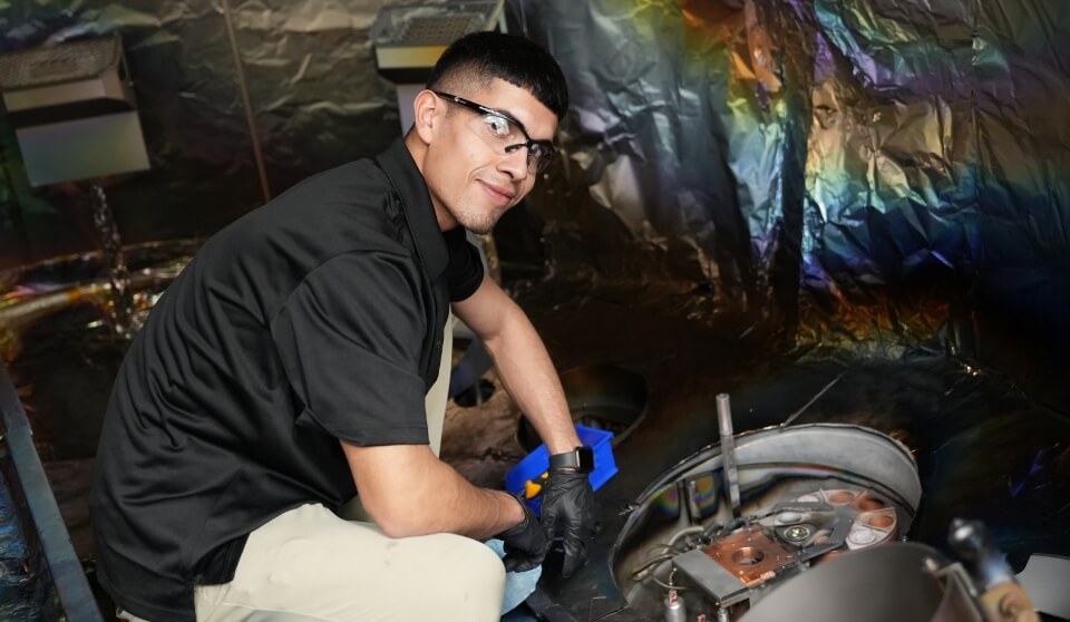 An FSI employee smiling while working on FSI equipment.