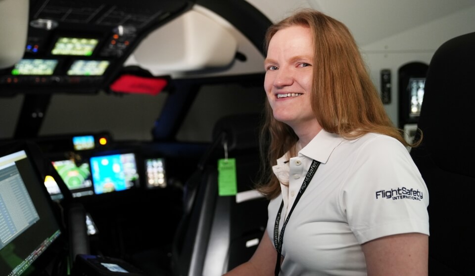 An FSI employee smiling in an FSI simulator.