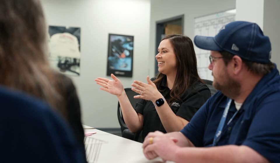 A group of FSI employees talking in a conference room.