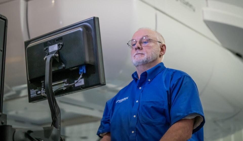 An FSI employee working at a standing computer.