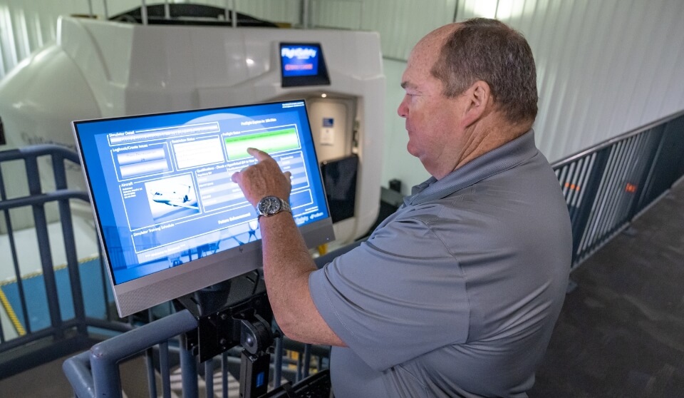 An FSI employee looking at data on a desktop monitor.