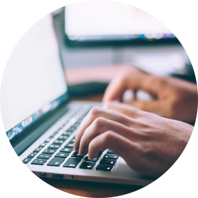 An employee types on a computer laptop keyboard.