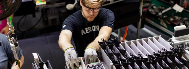  	A male material hanger works diligently at his station.