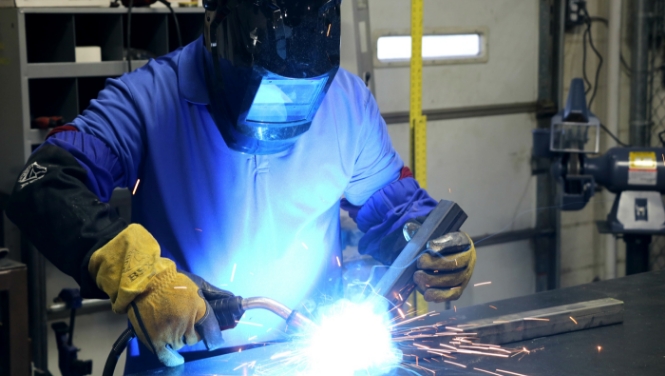  	A welder welds chair frames together.