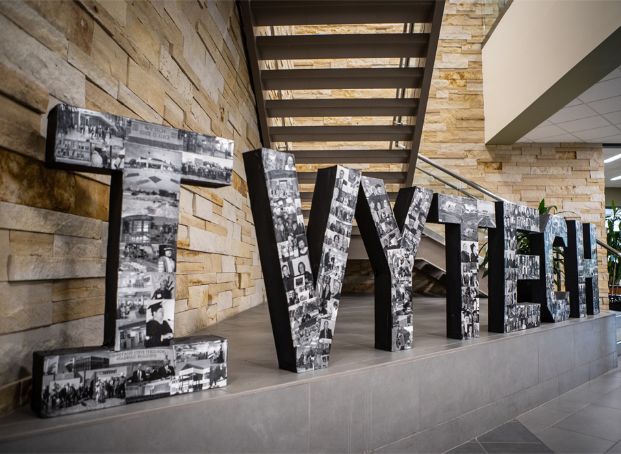Ivy Tech name in large stone letters on a ledge inside a building.