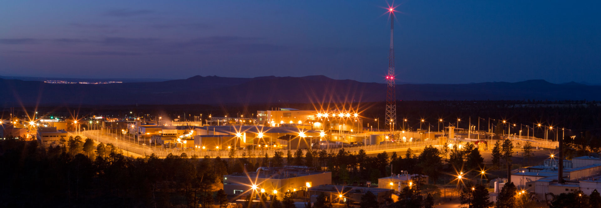 Aerial view of the lit up LANL campus at night.