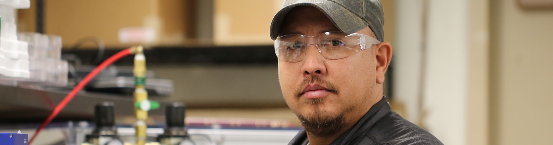 LANL employee wearing a military cap and protective glasses