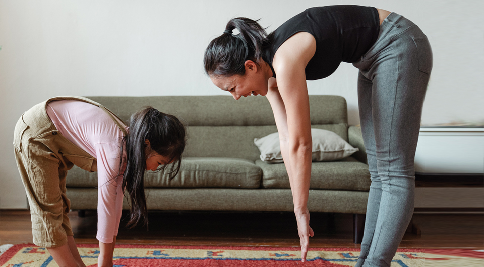 Una madre y su hija practican yoga juntas.