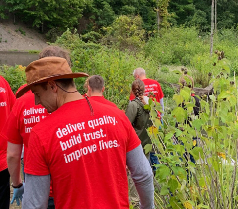 Oatey employees walking in nature during a park cleanup event.