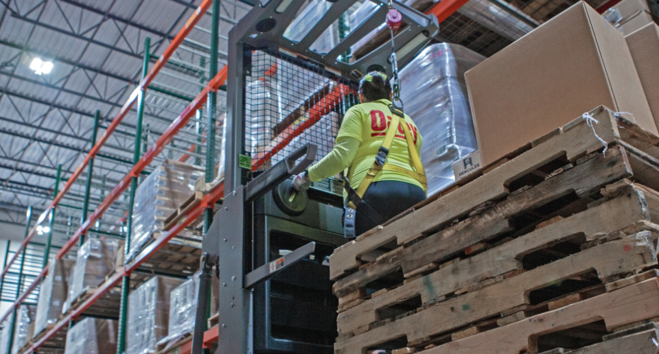 An Oatey distribution employee operating a large piece of warehouse equipment.