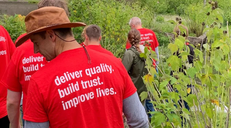 Oatey employees walking in nature during a park cleanup event.