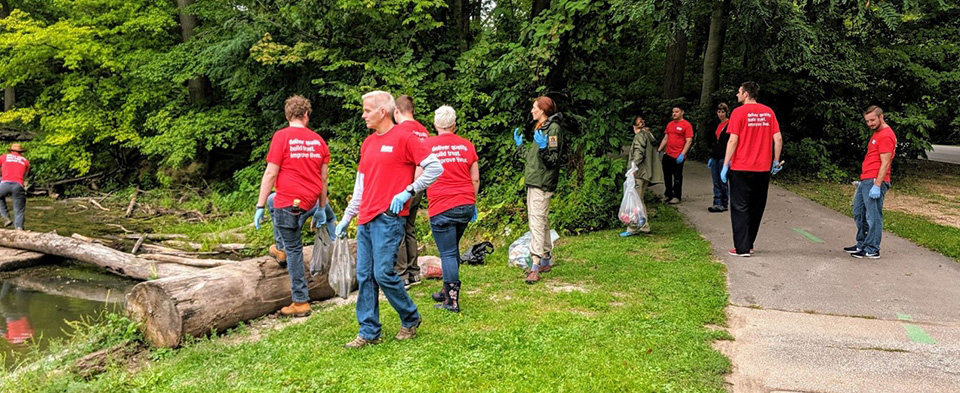 Oatey employees cleaning up garbage on a nature trail.