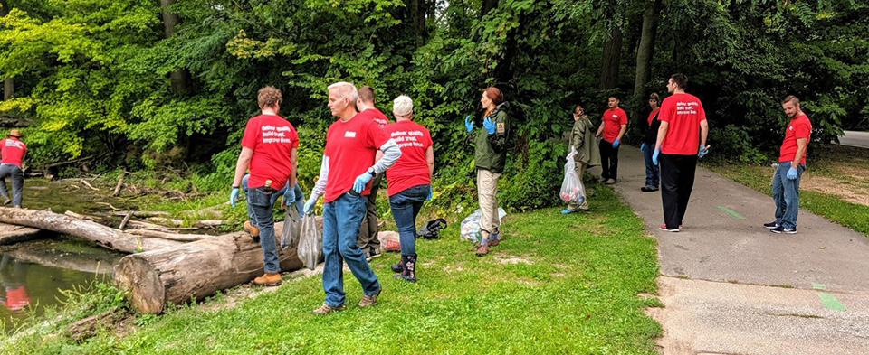 Des employés d’Oatey nettoient des déchets sur un sentier naturel.