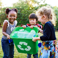 Des enfants tiennent un bac de recyclage contenant des bouteilles en plastique.