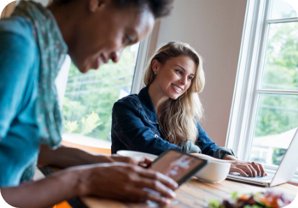 Women smiling while working on computers.