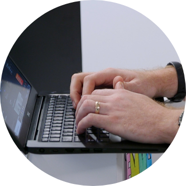 Hands typing on a laptop keyboard.