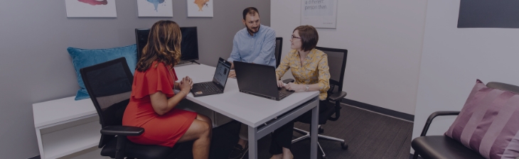  	PatientPoint employees working together at a table.