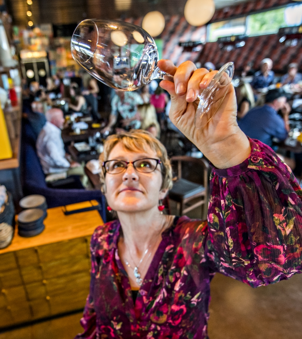  	Postino employee checking a wine glass.