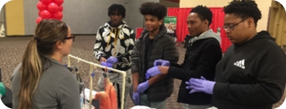 Students at a St. Elizabeth Healthcare event performing a medical experiment