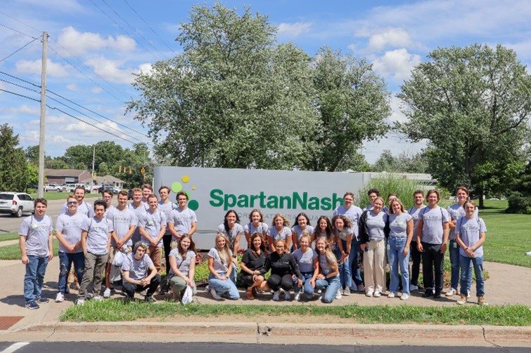 Group picture of SpartanNash interns in front of the SpartanNash sign.