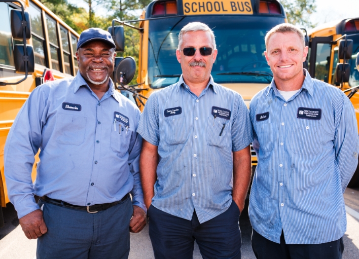 Three smiling mechanical professionals at Wake County Public School System.